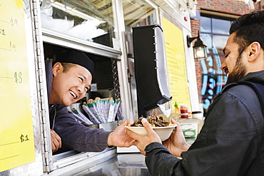 Man buying bowl of food at food truck