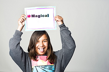 Hispanic girl holding magical sign above head