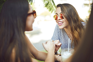 Smiling Hispanic women wearing sunglasses