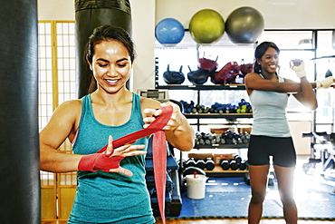 Woman wrapping hand in gymnasium