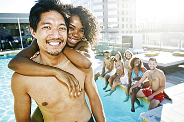 Smiling friends enjoying urban swimming pool