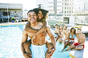 Smiling friends enjoying urban swimming pool