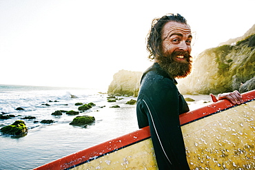 Caucasian man holding surfboard at beach