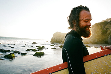 Caucasian man holding surfboard at beach