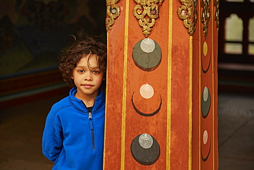 Mixed Race boy leaning on pillar