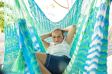 Caucasian girl laying in hammock