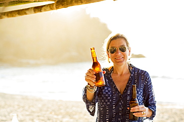 Caucasian woman holding two bottles of beer