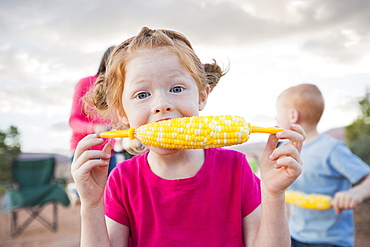 Caucasian girl eating corn on the cob