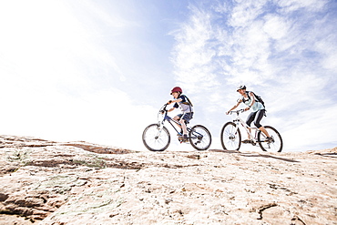 Caucasian mother and son riding mountain bikes