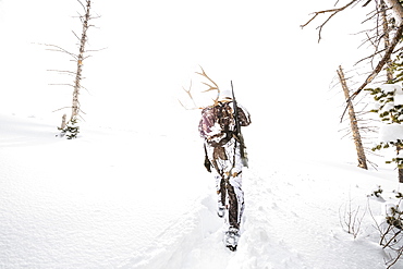 Caucasian woman hunting in forest carrying antlers