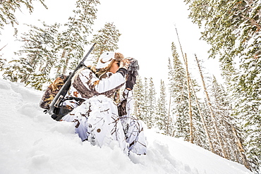 Caucasian woman hunting in forest using binoculars