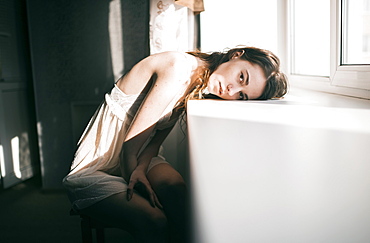 Caucasian woman leaning on windowsill