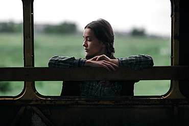 Caucasian woman leaning on empty bus