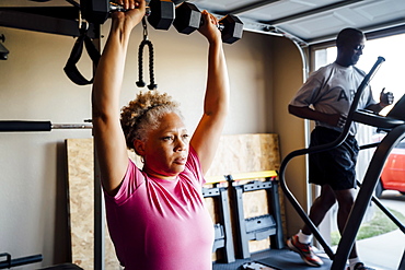 Black couple lifting working out in garage