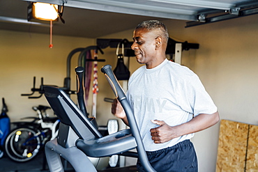 Black man running on treadmill in garage