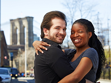 Smiling couple hugging in city