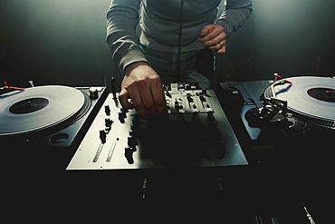 Caucasian disc jockey playing music in nightclub