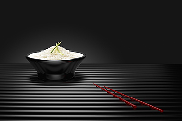 Chopsticks near bowl of white rice