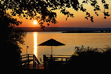 Deck silhouetted against lake at sunset, Grand Isle, Vermont, USA