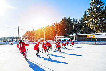 Caucasian boys playing ice hockey outdoors