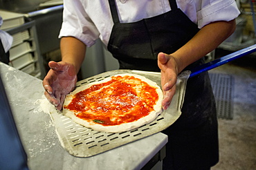 Man placing pizza on pizza peel