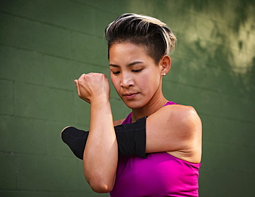 Athletic woman with amputated hand stretching arm