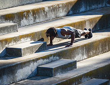 Athletic man doing push-ups on steps