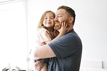 Father holding daughter (2-3)