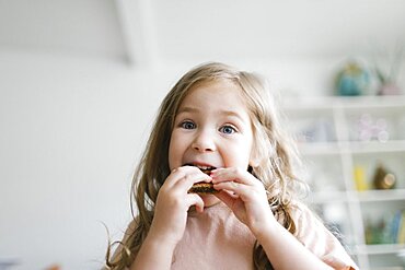 Girl (2-3) eating snack