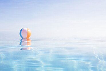 Beach ball floating on water surface