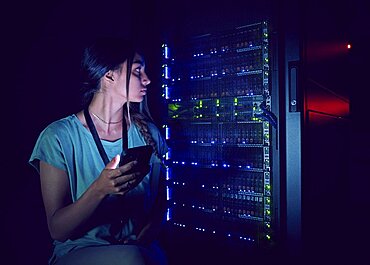 Technician with smart phone in server room