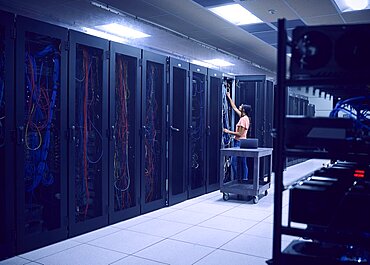 Female technician working in server room