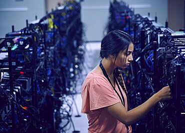 Female technician working in server room