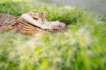 Portrait of woman lying on grass