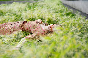 Portrait of woman lying on grass