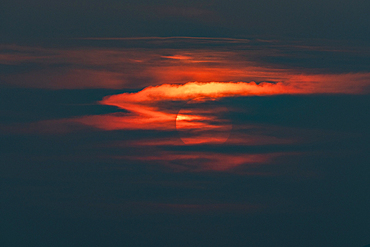 Sun behind clouds at sunset