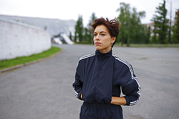 Serious brunette wearing tracksuit, looking away 