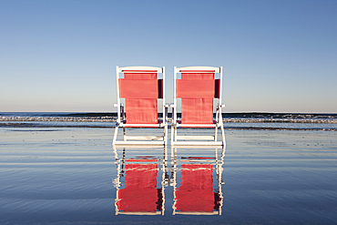 USA, Maine, York, Two beach chairs on wet sand beach