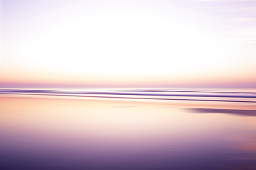 USA, New Jersey, Stone Harbor, Calm purple and orange water surface and sky at sunrise