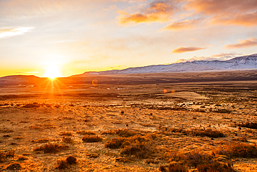 Argentina, Santa Cruz, El Calafate, Sun rising above plain landscape with mountains in distance