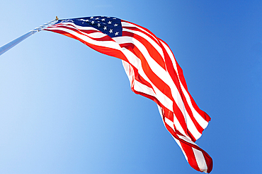 Ow angle view of American Flag against blue sky