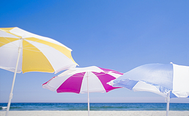 Colourful beach umbrellas against clear sky on beach