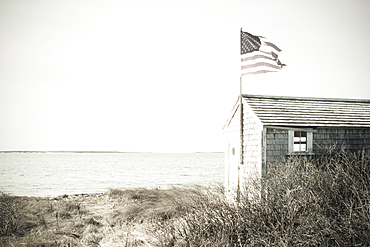 Seaside shed with American flag, black and white