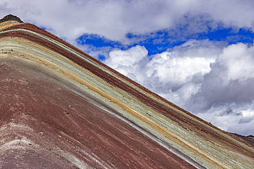 White puffy clouds over Rainbow Mountain