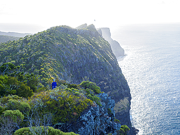 Woman hiking near cliff edge on Lord Howe Island, Lord Howe Island, New South Wales, Australia