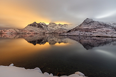 The light of the moon and snowy peaks reflected in the cold sea lit the night at Svolvaer, Lofoten Islands, Arctic, Norway, Scandinavia, Europe