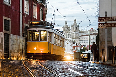 Romantic atmosphere in the old streets of Alfama with the castle in the background and tram number 28, Lisbon, Portugal, Europe