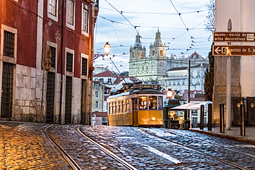 Romantic atmosphere in the old streets of Alfama with the castle in the background and tram number 28, Lisbon, Portugal, Europe