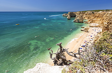 Tourists on sandy beach at Praia da Marinha surrounded by turquoise ocean, Caramujeira, Lagoa Municipality, Algarve, Portugal, Europe