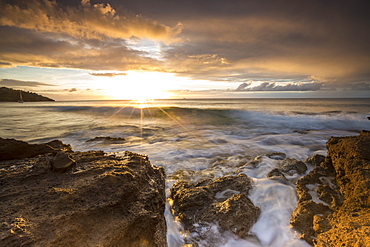 The last sunbeams on the cliffs and sea around Galley Bay, St. John's, Antigua, Antigua and Barbuda, Leeward Islands, West Indies, Caribbean, Central America